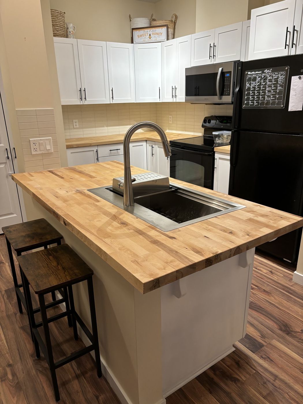 Kitchen with butcher block island and white shaker cabinets